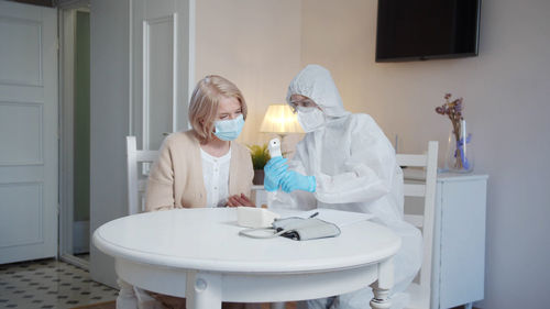 Doctor wearing mask examining patient in clinic