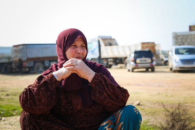 Portrait of young woman sitting on road