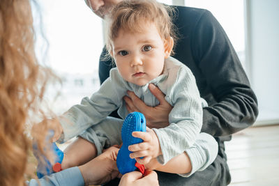 Mom and dad put shoes on the baby. high quality photo