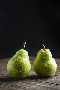 Close-up of fruits on table against black background