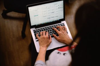 Close-up of woman using laptop at home