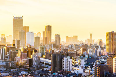 Aerial view of buildings in city against sky during sunset