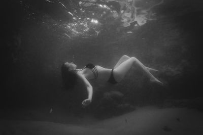 Young woman swimming underwater in sea