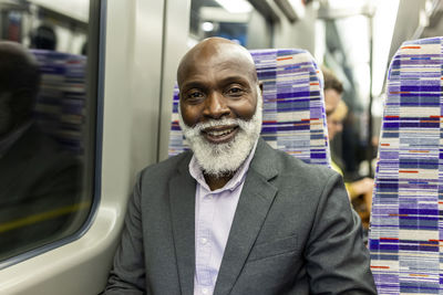 Smiling commuter with beard traveling in train