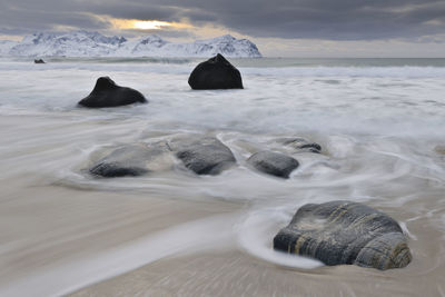 Rocks on sandy beach, lofoten, nordland, norway