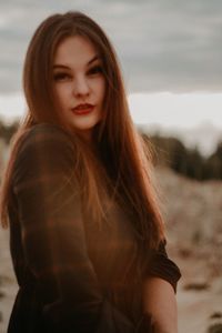 Portrait of smiling young woman standing at beach