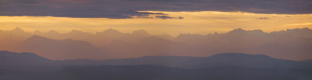 Scenic view of mountains against sky at sunset