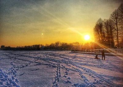Snow covered field at sunset