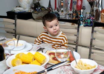 Curious little boy sitting at thanksgiving table