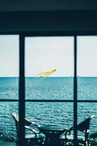 Scenic view of sea against sky seen through window