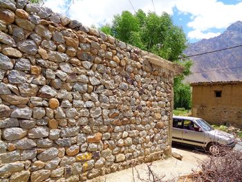 Stone wall of old building against sky