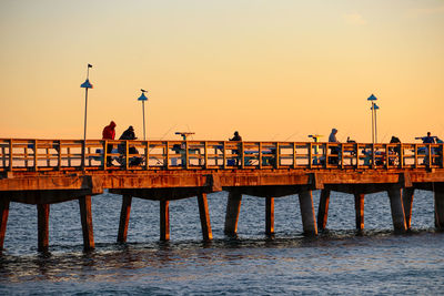 Pier on sea at sunset