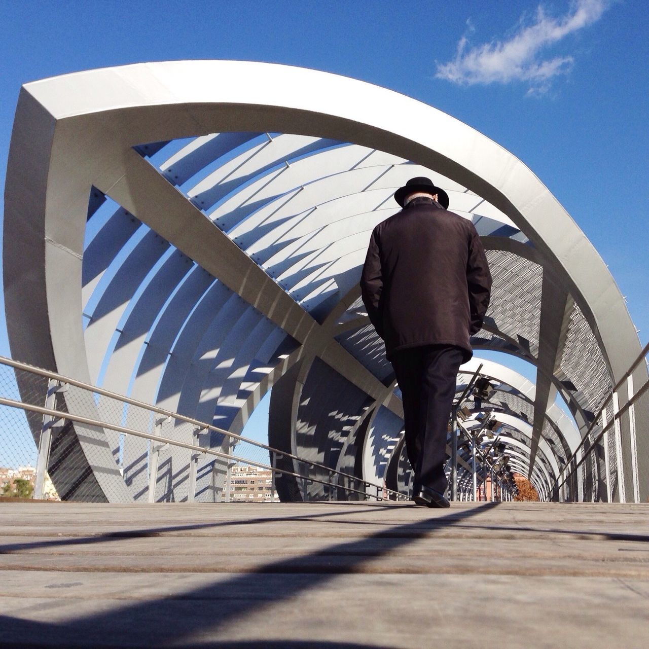 built structure, architecture, railing, sunlight, blue, full length, sky, shadow, low angle view, day, lifestyles, leisure activity, steps, rear view, standing, bridge - man made structure, walking, men