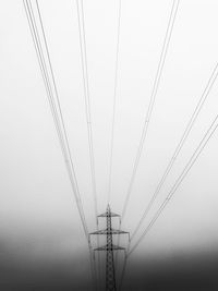 Low angle view of electricity pylon against clear sky