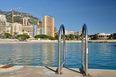 Sea by swimming pool against buildings in city