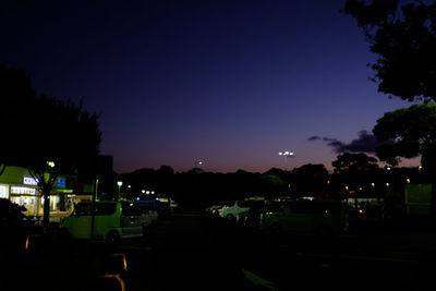 Illuminated street against sky at night