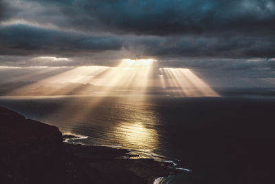 Scenic view of sea against cloudy sky during sunset