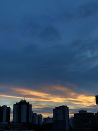 Silhouette buildings against sky during sunset