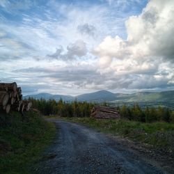 Dirt road along landscape and against sky