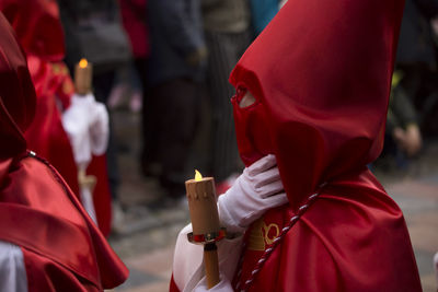 Midsection of people holding cross against blurred background