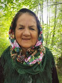 Portrait of smiling woman against trees