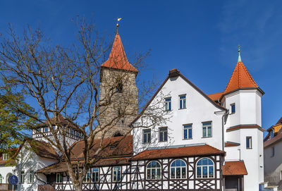 Low angle view of trees and building against sky