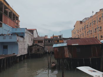 Canal amidst buildings in city against sky