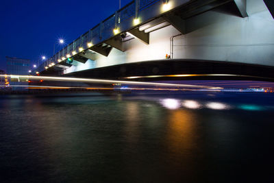 Light trails on bridge in city at night