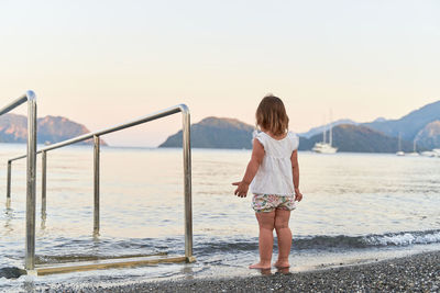 Rear view of girl looking at sea