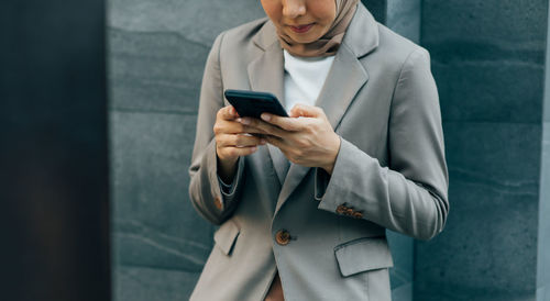 Midsection of man using mobile phone