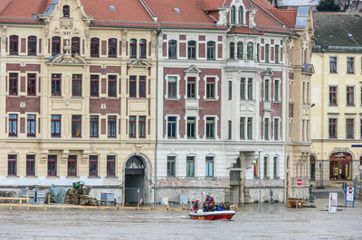 People in a boat  in front of building