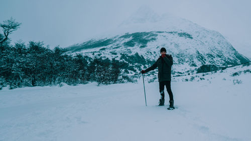 Full length of person standing on snow covered field