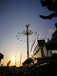 Low angle view of silhouette ferris wheel at sunset