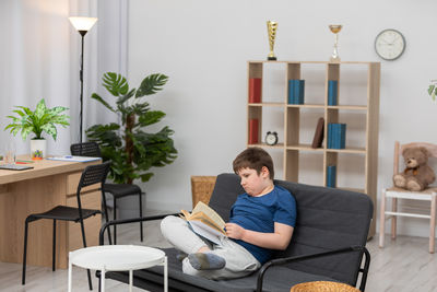 Young woman sitting on sofa at home