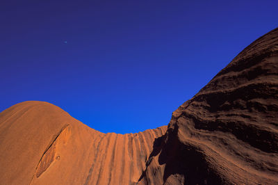 Scenic view of desert against clear blue sky