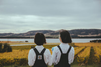 Rear view of couple looking at mountains against sky