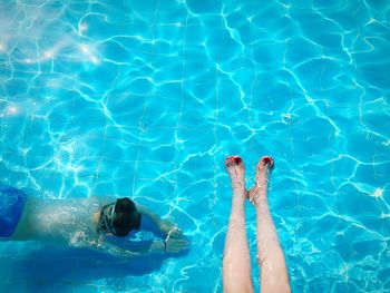 Low section of person standing in swimming pool