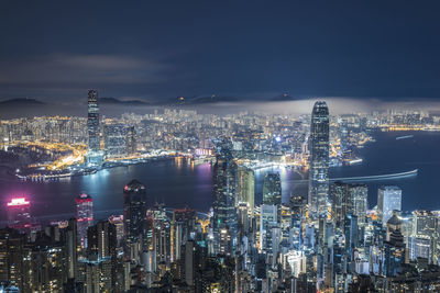 Illuminated cityscape against sky at night