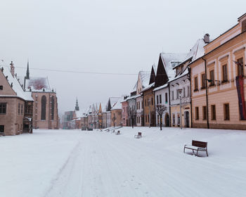 Houses and buildings in city against clear sky