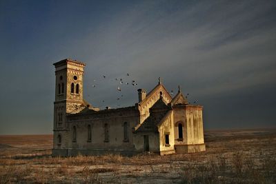 Old building on field against sky