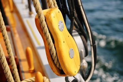 Close-up of yellow metal hanging on wood