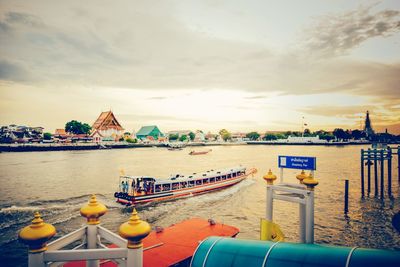 Boats moored in sea against sky during sunset
