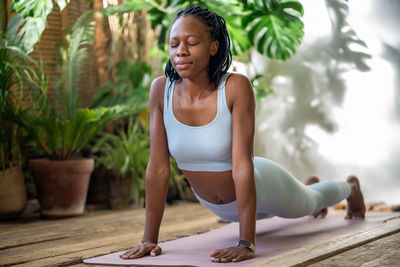 Relaxed black mindfulness woman do yoga, stretching on fitness mat. pilates at home, sported workout