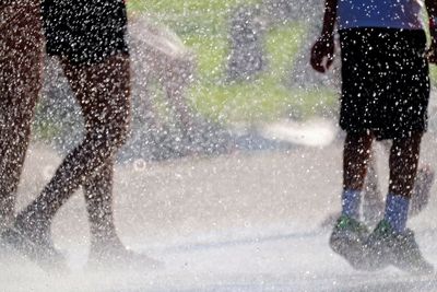 Low section of people running on wet street