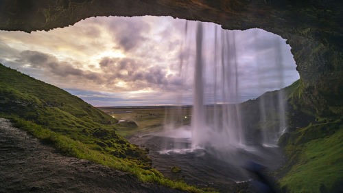 Scenic view of waterfall against sky