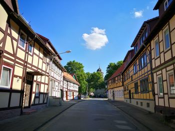 Empty road amidst buildings in town