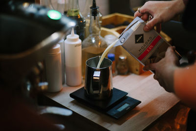 Midsection of person holding coffee cup on table