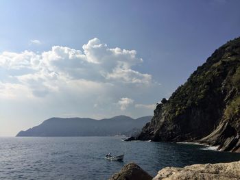 Scenic view of sea and mountains against sky