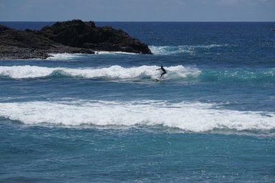 Man surfing in sea against sky