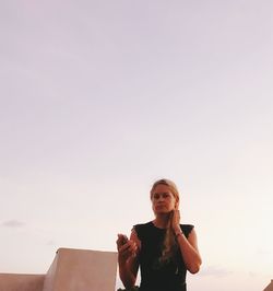 Portrait of woman standing against sky